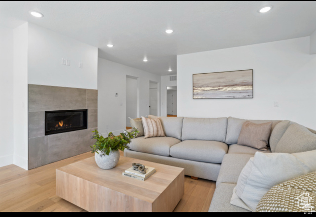 Living room featuring light hardwood / wood-style floors and a tiled fireplace