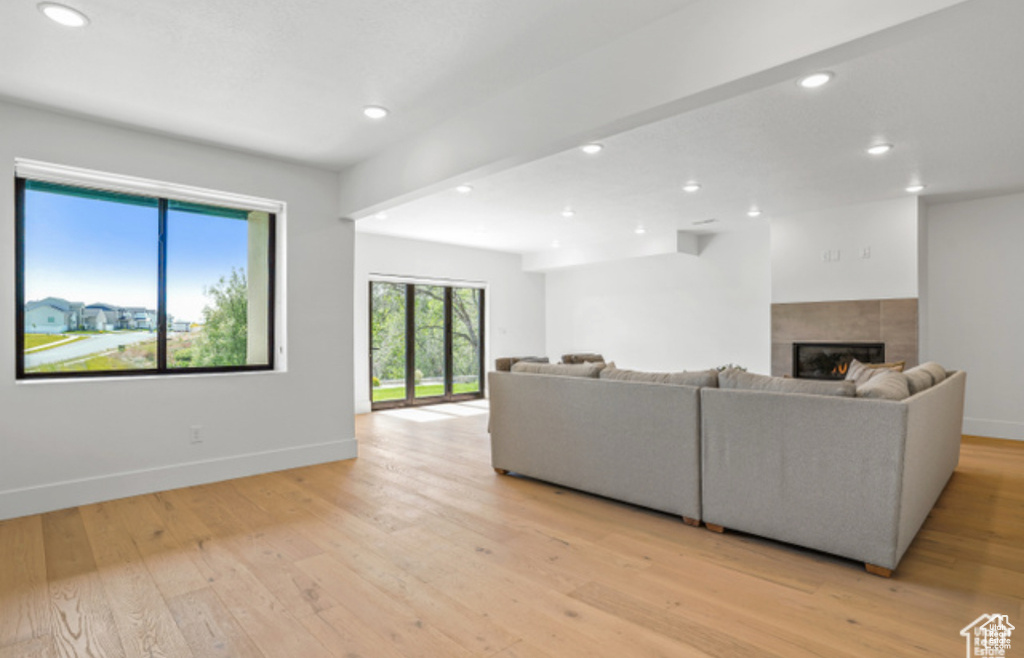 Living room with a tile fireplace and light wood-type flooring