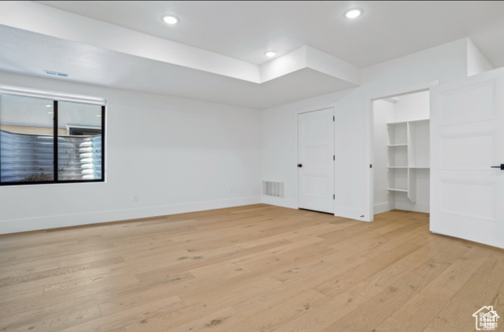 Unfurnished bedroom featuring a walk in closet and light wood-type flooring