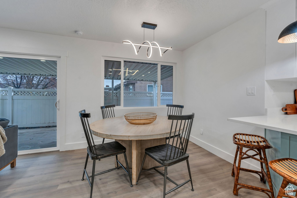 Dining area with hardwood / wood-style flooring and a chandelier