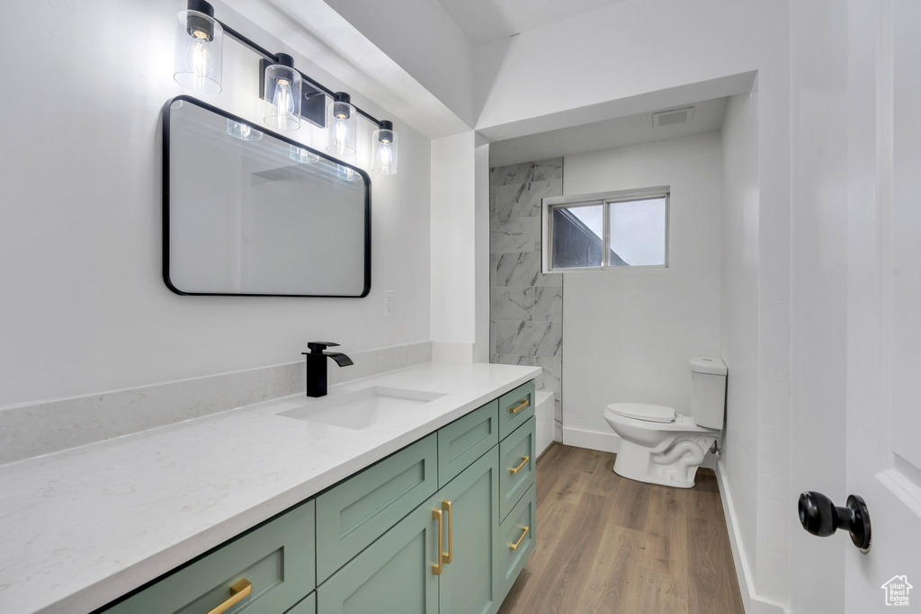 Bathroom featuring hardwood / wood-style floors, vanity, and toilet