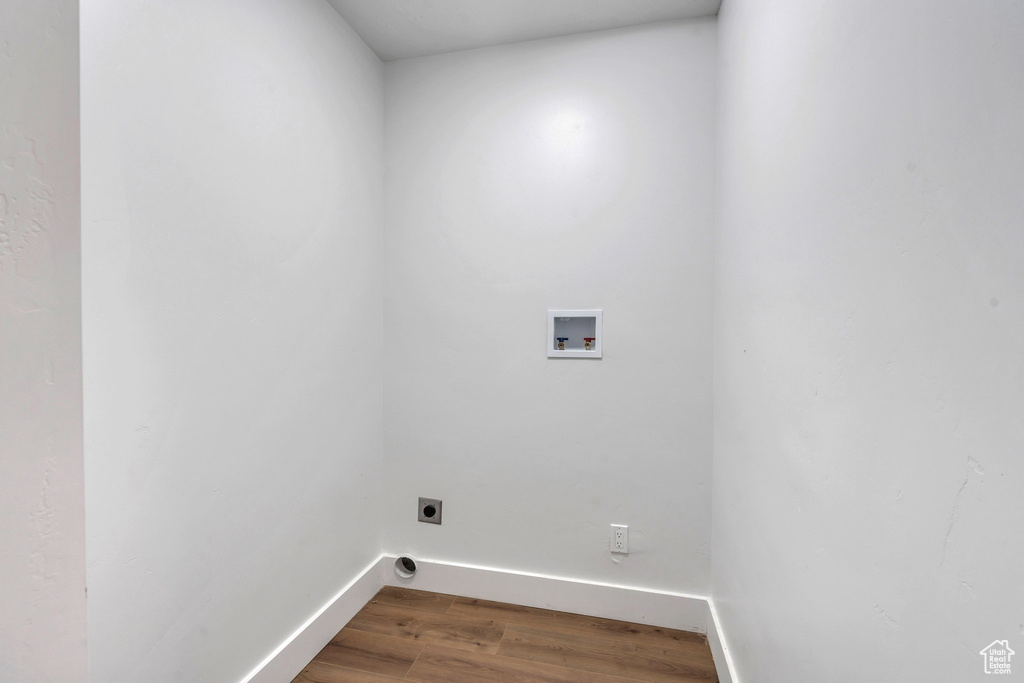 Laundry room with hardwood / wood-style flooring, washer hookup, and hookup for an electric dryer