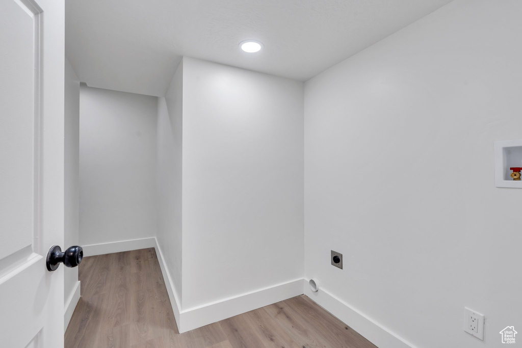 Laundry room with electric dryer hookup, washer hookup, and light wood-type flooring