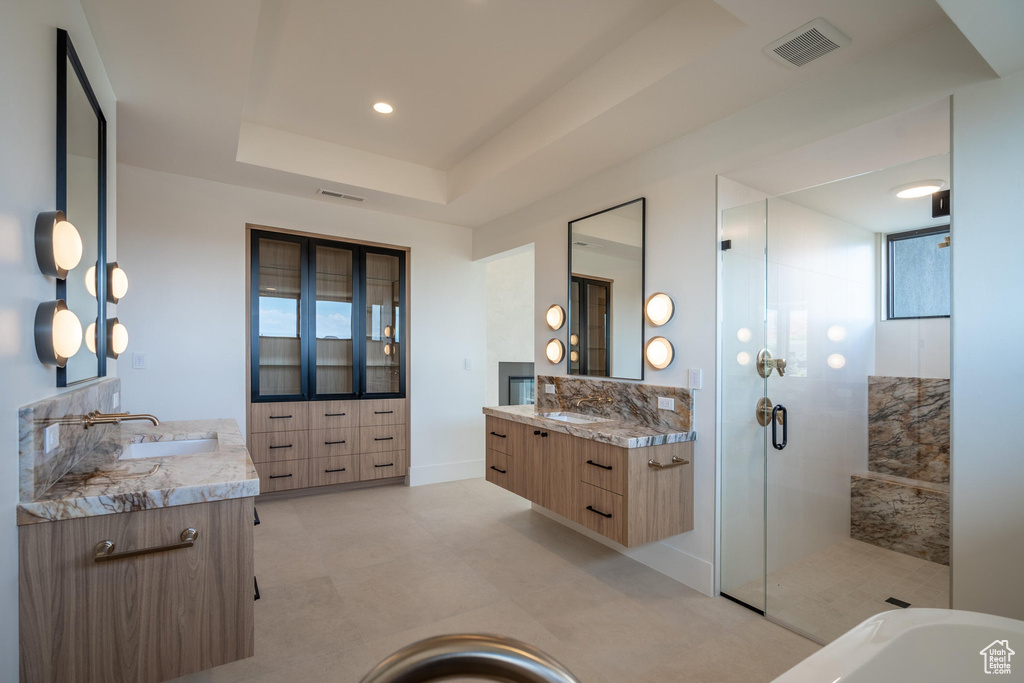 Bathroom with vanity, a tray ceiling, and a shower with shower door