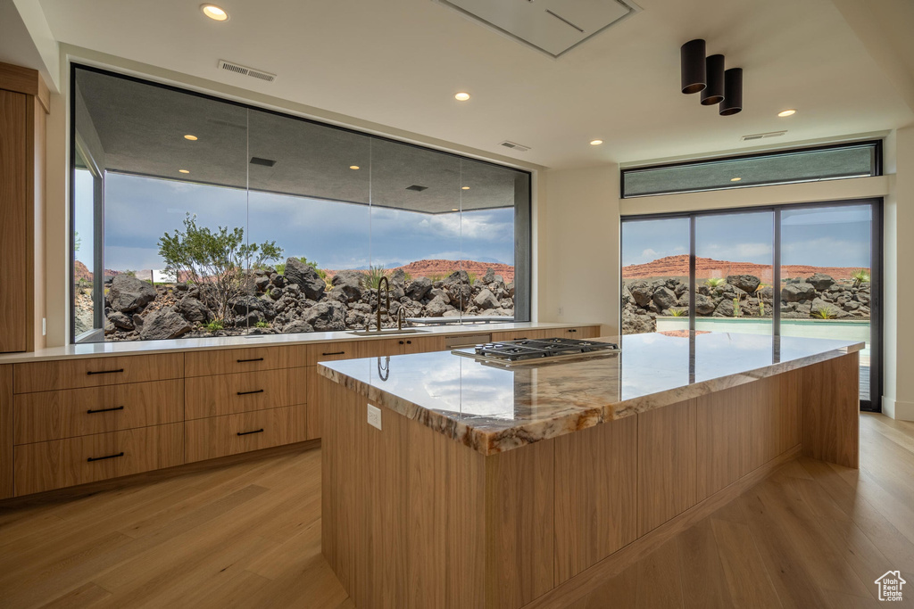 Kitchen featuring a large island, sink, stainless steel gas cooktop, a mountain view, and light hardwood / wood-style floors