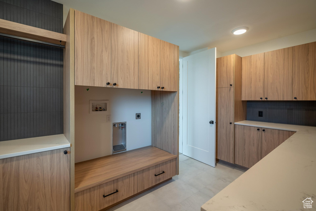 Clothes washing area with washer hookup, cabinets, and hookup for an electric dryer
