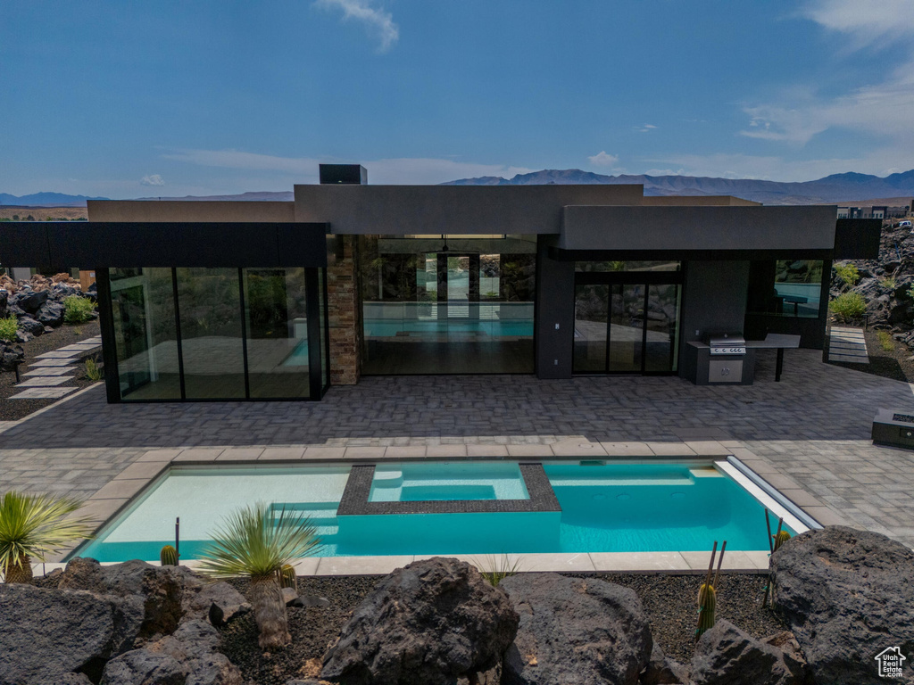View of pool featuring a mountain view, a patio, and grilling area