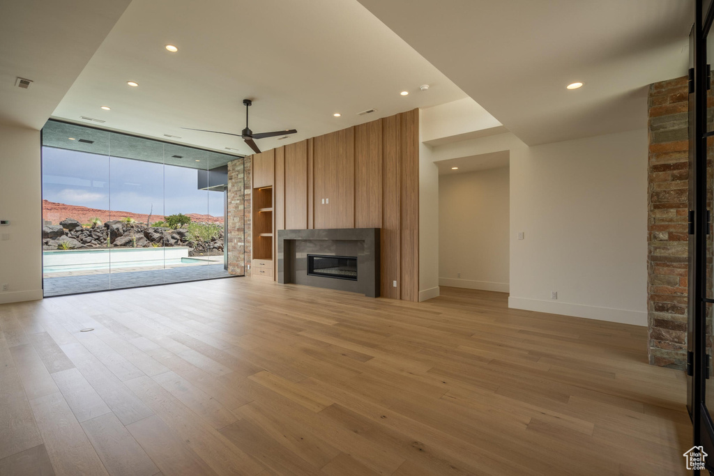 Unfurnished living room with ceiling fan and light hardwood / wood-style floors