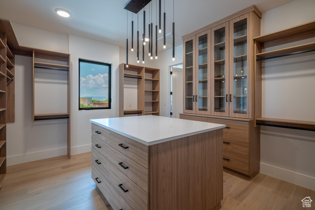 Walk in closet with light wood-type flooring