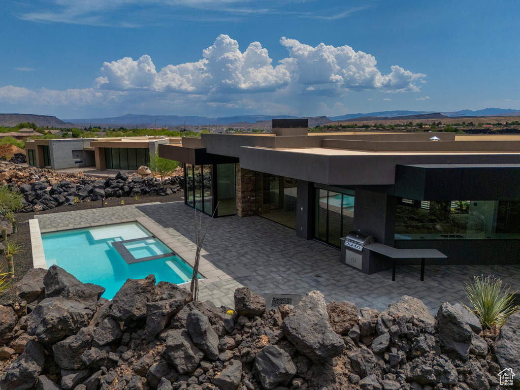 View of pool with a mountain view, area for grilling, an in ground hot tub, and a patio area