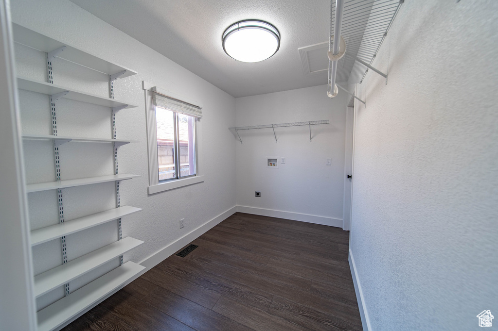Washroom with electric dryer hookup, dark wood-type flooring, and hookup for a washing machine