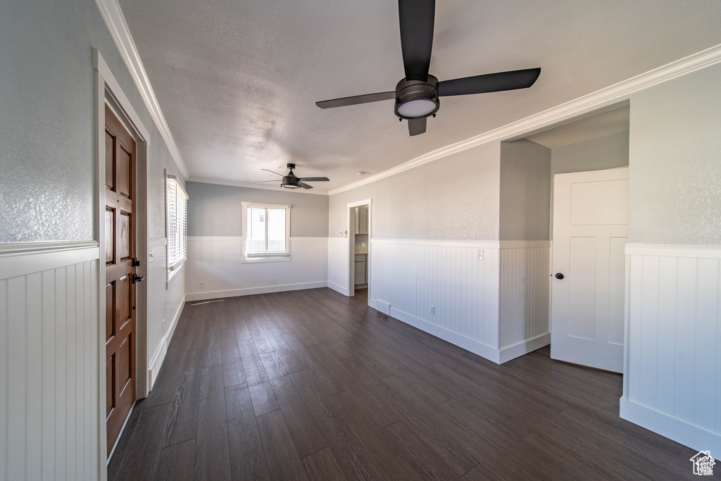Unfurnished room with ceiling fan, dark hardwood / wood-style flooring, and crown molding