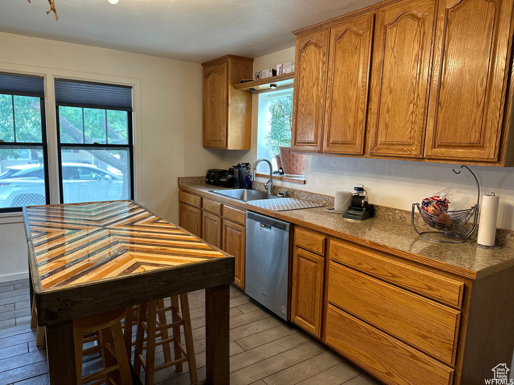 Kitchen with dishwasher, light hardwood / wood-style floors, and sink