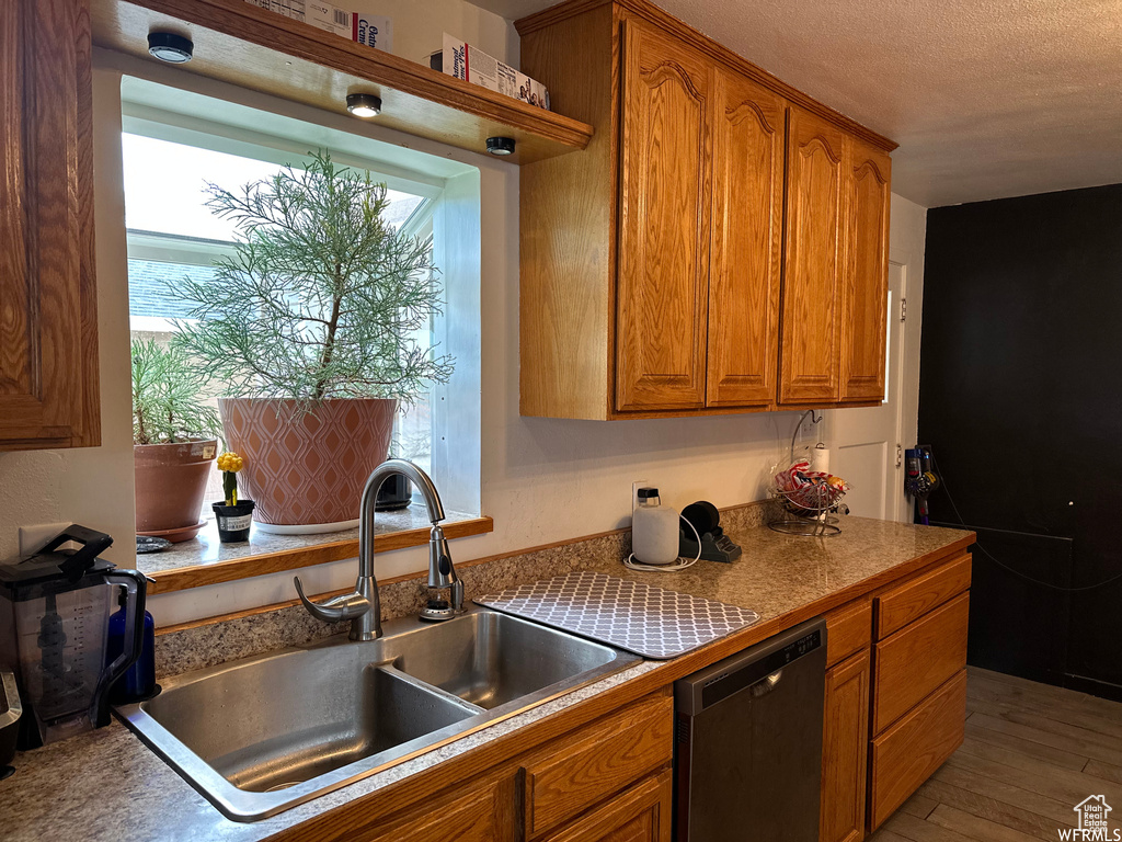 Kitchen with dishwasher, wood-type flooring, a textured ceiling, and sink
