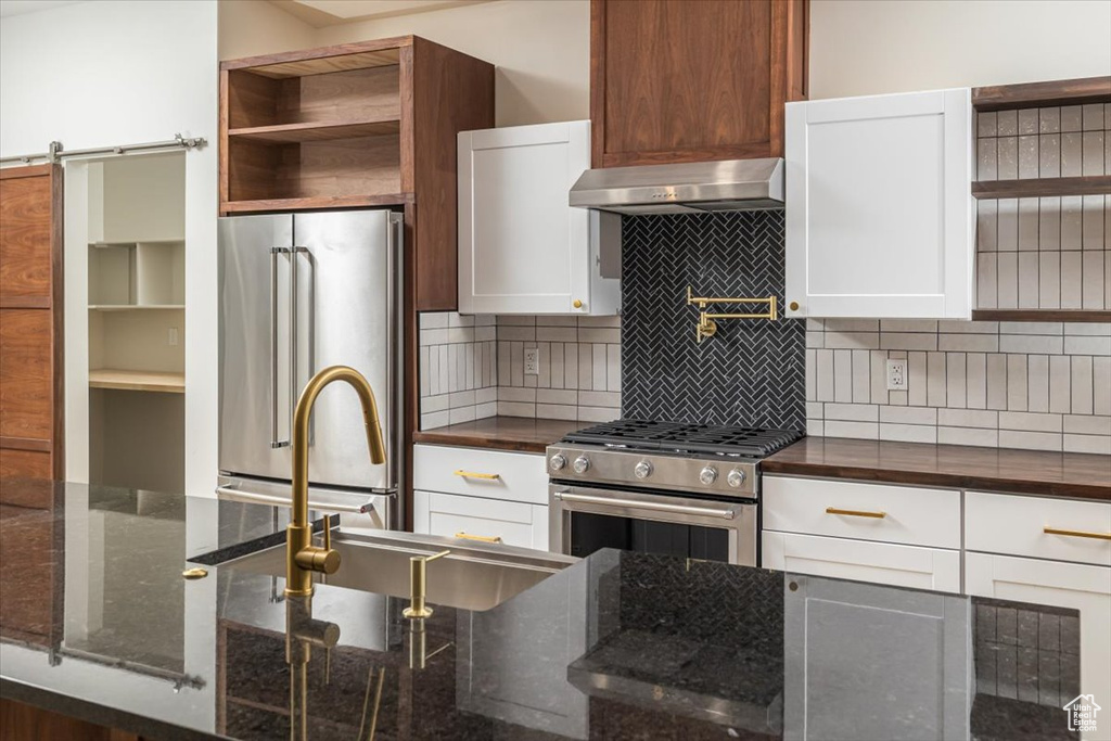 Kitchen featuring white cabinetry and high end appliances