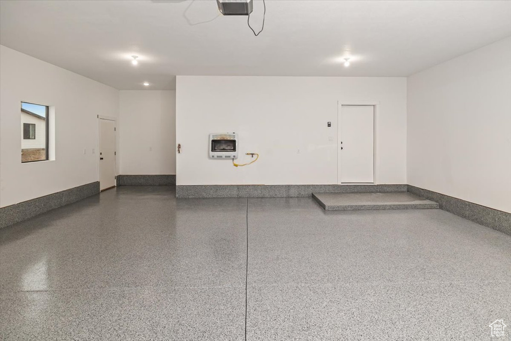 Garage featuring heating unit and a garage door opener