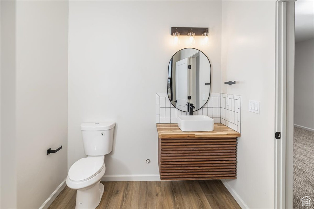 Bathroom featuring vanity, wood-type flooring, and toilet