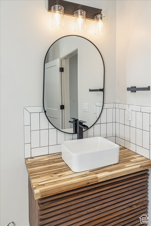 Bathroom featuring tasteful backsplash and vanity