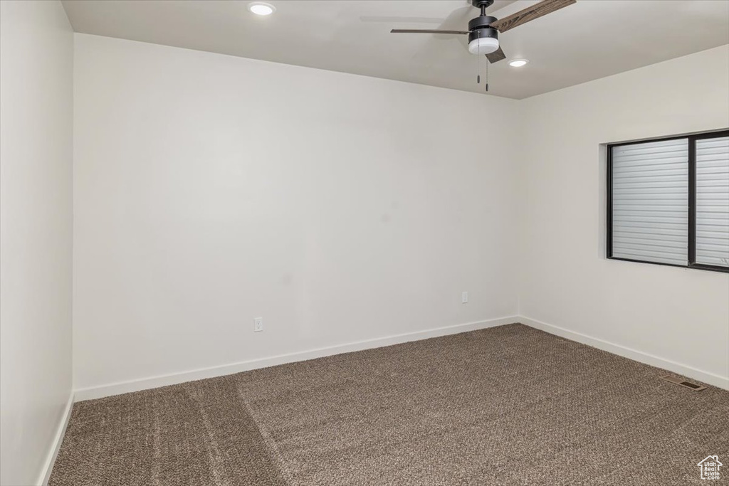 Carpeted empty room with ceiling fan