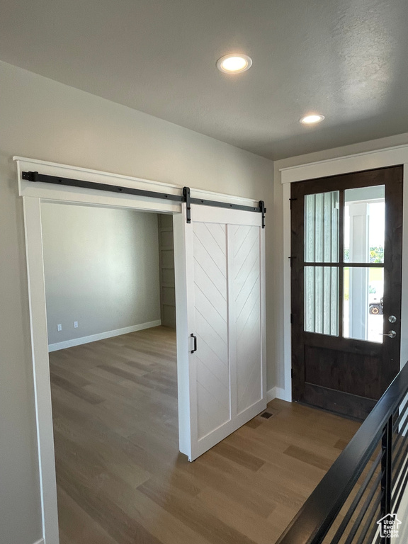 Entrance foyer with hardwood / wood-style floors and a barn door