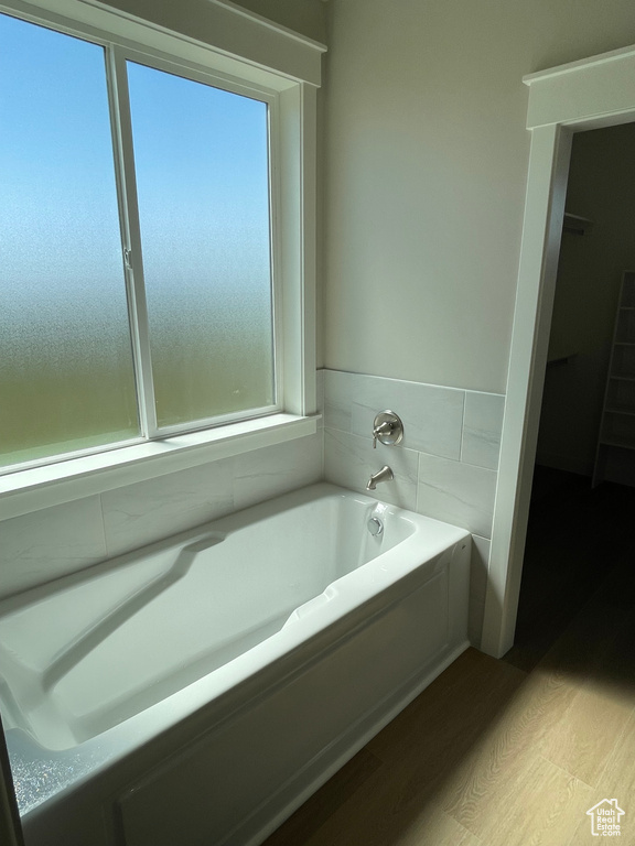 Bathroom featuring hardwood / wood-style floors and a washtub