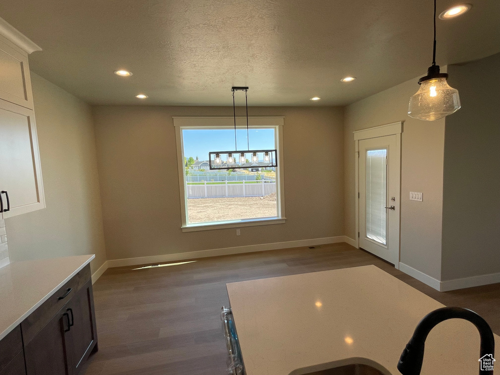 Unfurnished dining area with dark hardwood / wood-style floors and a textured ceiling