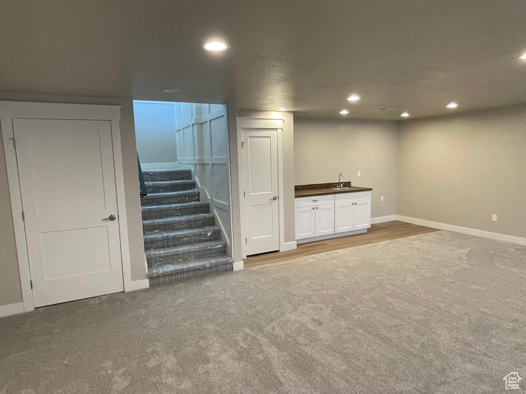 Basement featuring carpet and sink