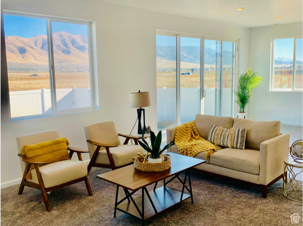 Living room with a mountain view, carpet floors, and a wealth of natural light