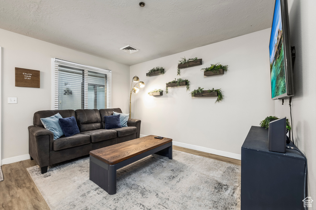 Living room with hardwood / wood-style floors and a textured ceiling