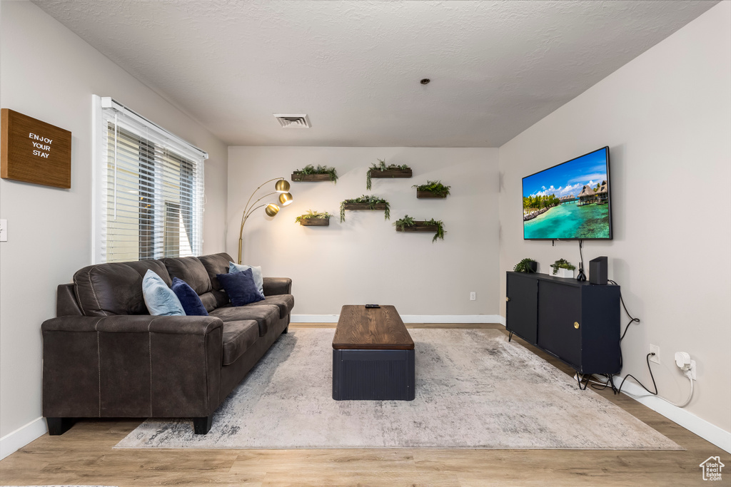 Living room featuring a textured ceiling and hardwood / wood-style flooring