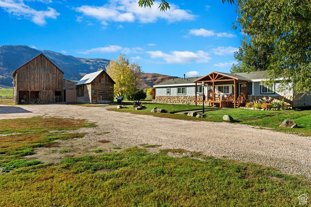 Ranch-style house with an outdoor structure, a mountain view, and a front yard