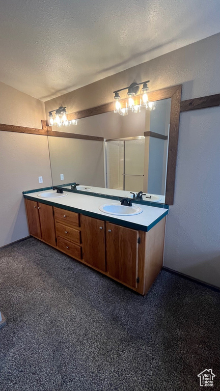 Bathroom with vanity, an enclosed shower, and a textured ceiling