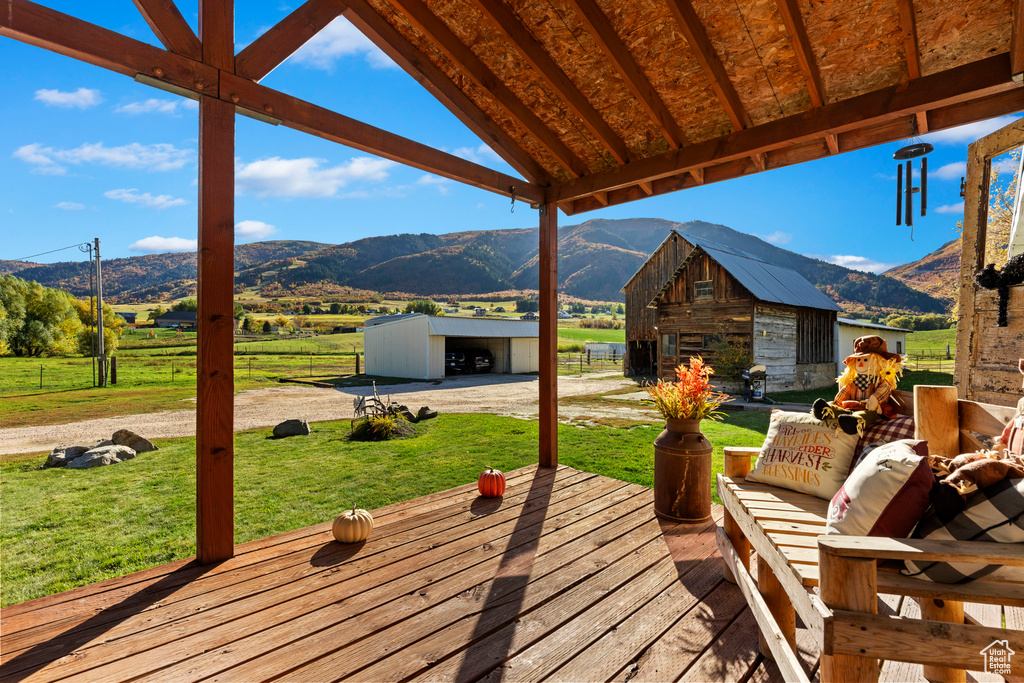 Deck featuring an outbuilding, a mountain view, and a rural view