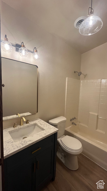 Full bathroom with shower / tub combination, toilet, vanity, and hardwood / wood-style flooring