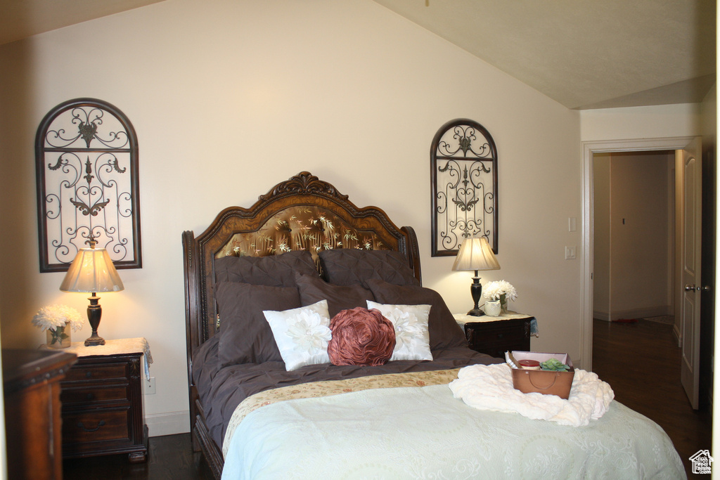 Bedroom featuring dark wood-type flooring and vaulted ceiling