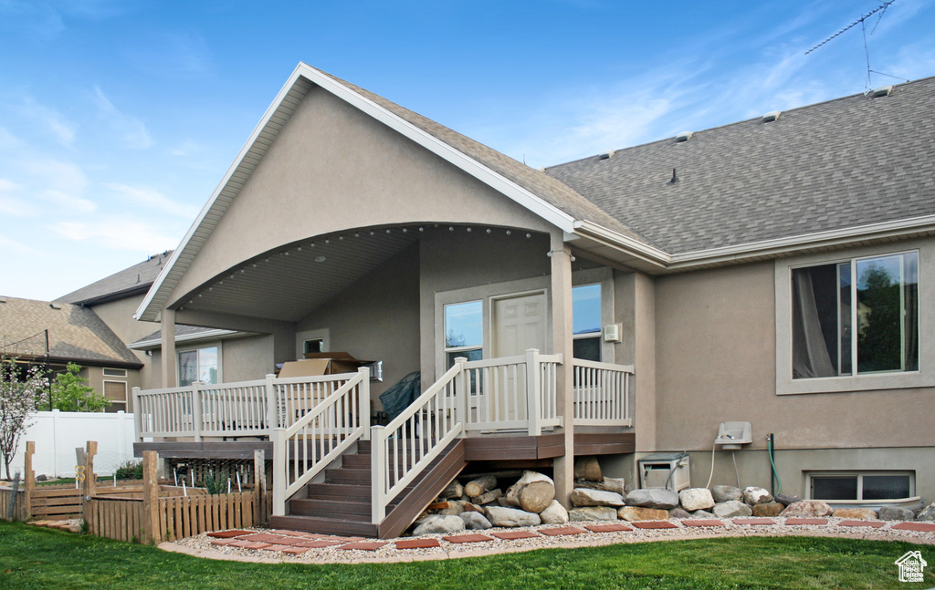 Rear view of property with a deck and a lawn