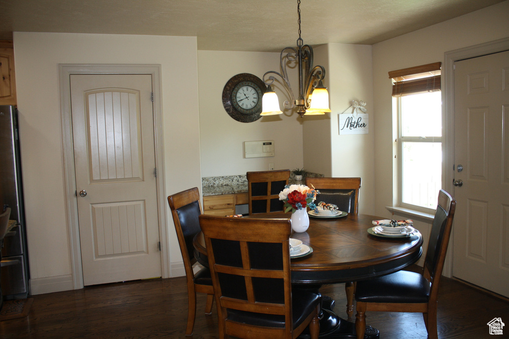 Dining space featuring dark hardwood / wood-style flooring and a notable chandelier