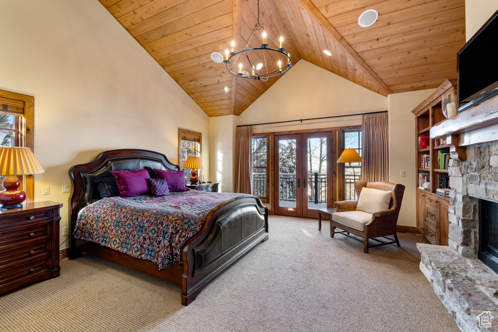 Bedroom with wooden ceiling, french doors, access to exterior, a fireplace, and light colored carpet