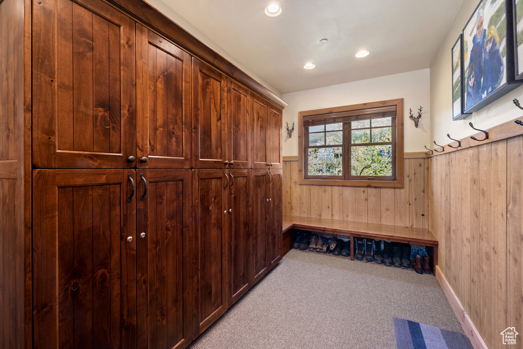 Mudroom featuring light carpet and wooden walls