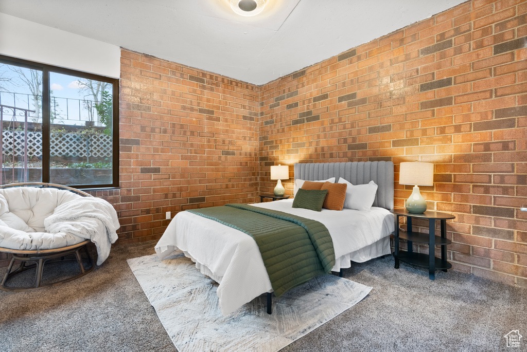 Bedroom with carpet and brick wall