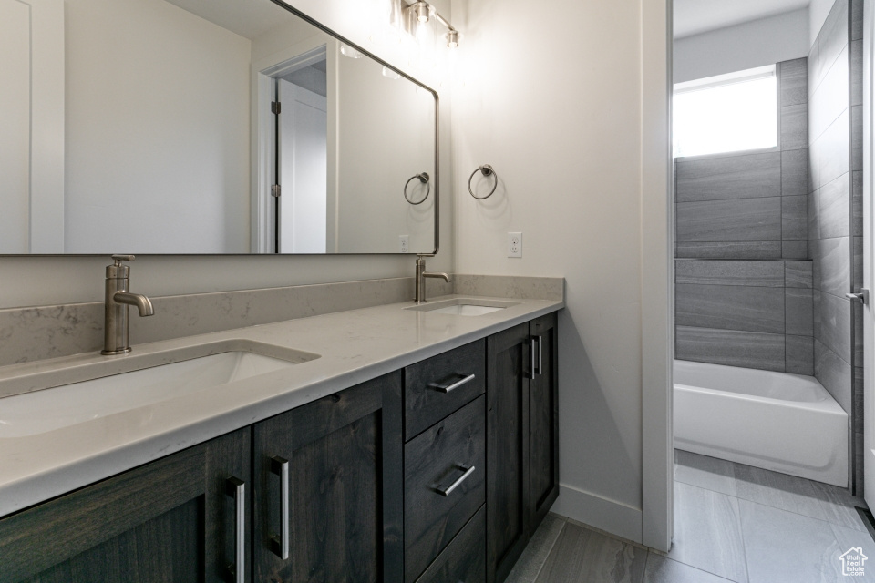 Bathroom featuring baseboards, a sink, and double vanity