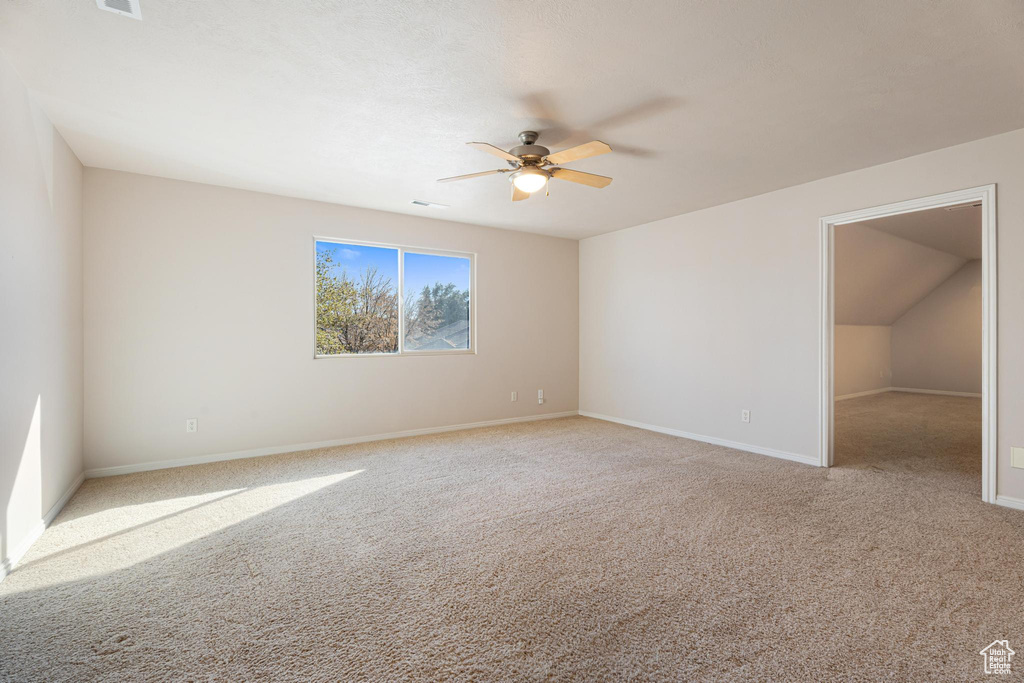 Carpeted spare room featuring ceiling fan