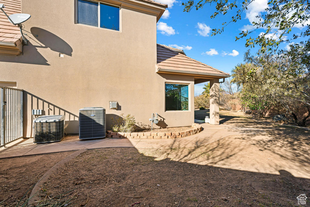 Rear view of house with cooling unit and a patio area