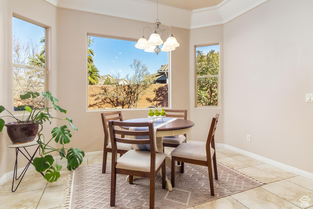 Dining area featuring light tile patterned floors, a wealth of natural light, and an inviting chandelier