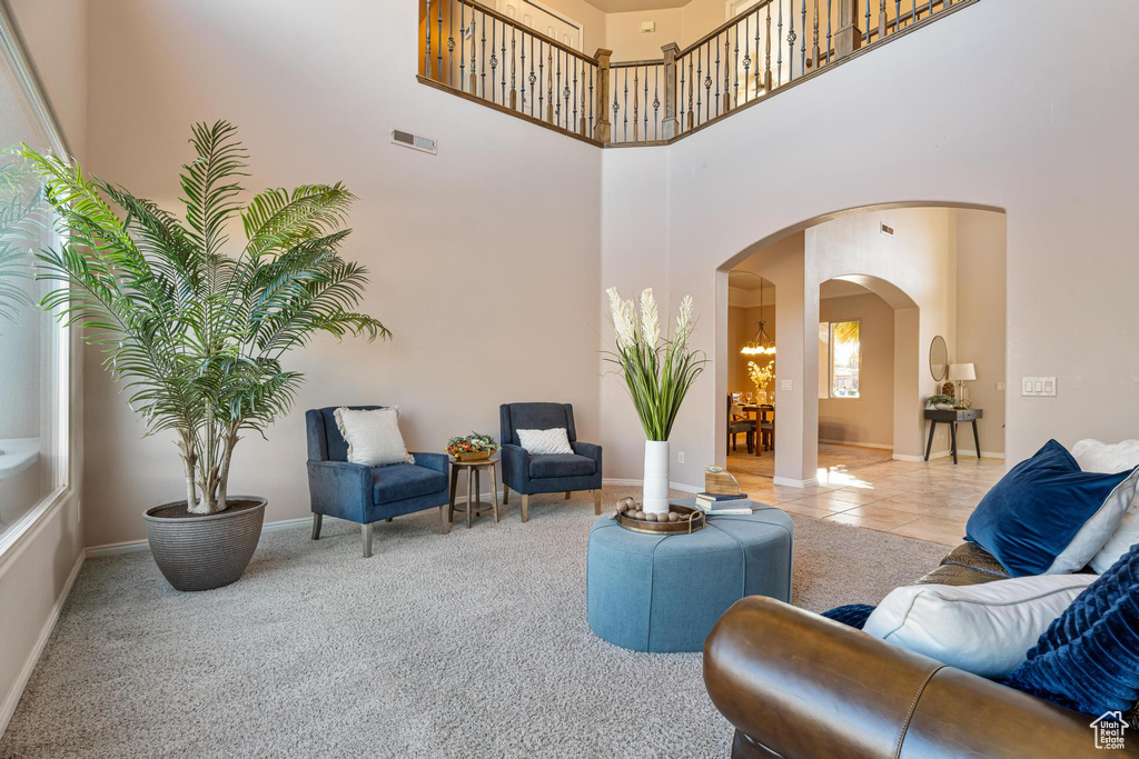 Living room featuring a towering ceiling and light tile patterned floors
