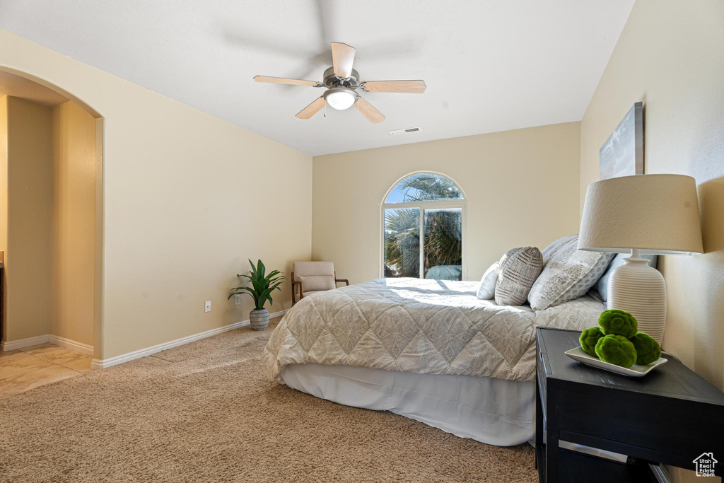 Carpeted bedroom featuring ceiling fan