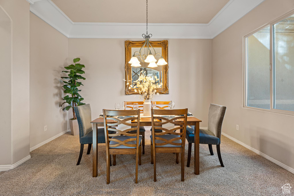 Dining area featuring carpet flooring, a notable chandelier, plenty of natural light, and ornamental molding