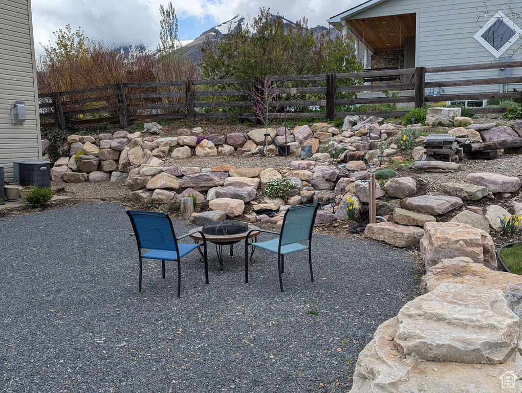 View of yard featuring fence, a patio, cooling unit, and an outdoor fire pit