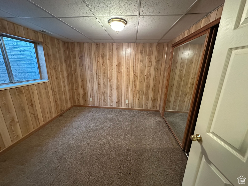 Basement featuring carpet flooring and a paneled ceiling