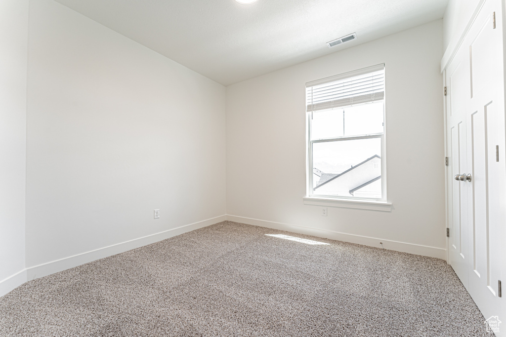 Spare room featuring carpet floors and baseboards